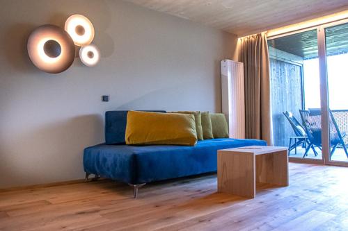 a living room with a blue couch and a table at feldthurnerhof vinum-natur-relax in Feldthurns