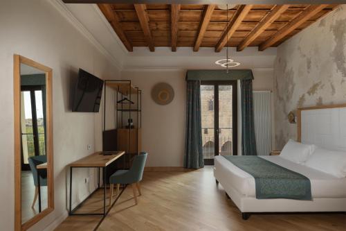 a bedroom with a bed and a desk and a table at Cà Uberti Palace Hotel, MantegnaHotels in Mantova