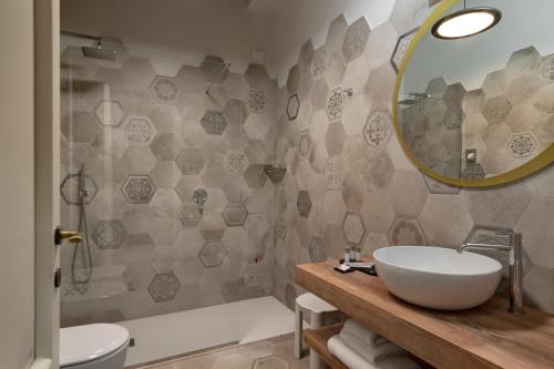 a bathroom with a sink and a mirror and a tub at Cà Uberti Palace Hotel, MantegnaHotels in Mantova