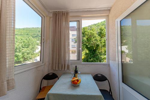 - une salle à manger avec une table et deux fenêtres dans l'établissement Apartment Knezevic, à Petrovac na Moru