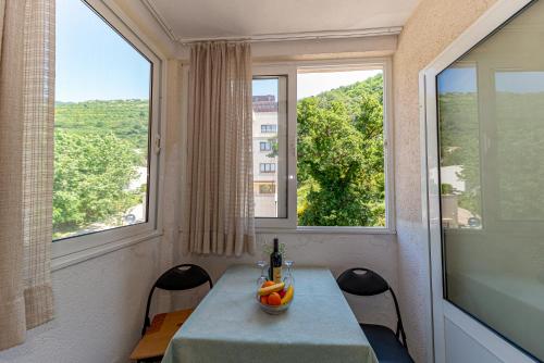 uma sala de jantar com uma mesa e duas janelas em Apartment Knezevic em Petrovac na Moru