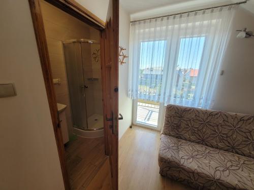 カルビアにあるPokoje gościnne Haniaのバスルーム(シャワー、トイレ付)、窓が備わります。