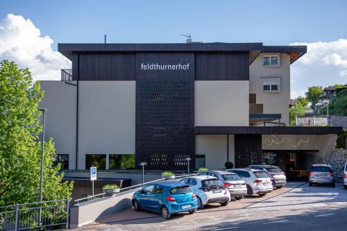 a parking lot with cars parked in front of a building at feldthurnerhof vinum-natur-relax in Feldthurns