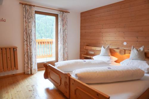 two twin beds in a bedroom with a window at Naturhotel BERGhof in Pfunds