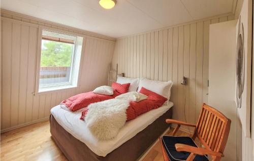 a bedroom with a bed with a white dog laying on it at 4 Bedroom Lovely Home In Hebnes in Hebnes