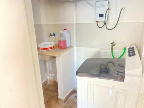 a small white kitchen with a sink and a counter at Apto. Luxury con Piscina “Brisa del paraíso¨ in Concepción de La Vega