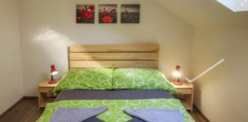 a bedroom with a green bed and two lamps at Apartmán na Koskách in Třeboň