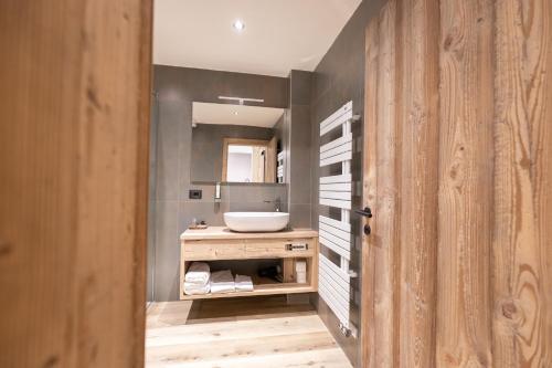 a bathroom with a sink and a mirror at Hotel Alpenrose Wellness in Vattaro