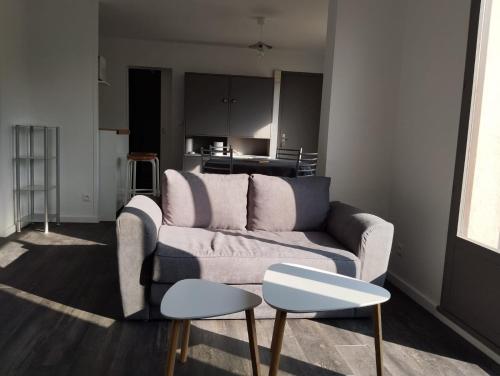 un salon avec un canapé et une table dans l'établissement Cottage à 2 mn à pied de la mer, à Merville-Franceville-Plage