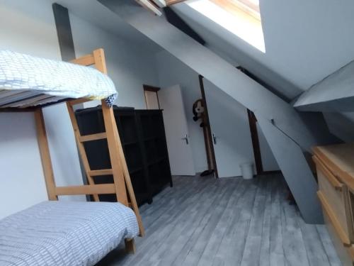 une chambre avec un lit superposé et une échelle dans l'établissement Cottage à 2 mn à pied de la mer, à Merville-Franceville-Plage