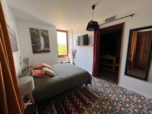 a hotel room with a bed and a window at Les Baroudeurs de Saint Jean in Saint-Jean-de-Barrou