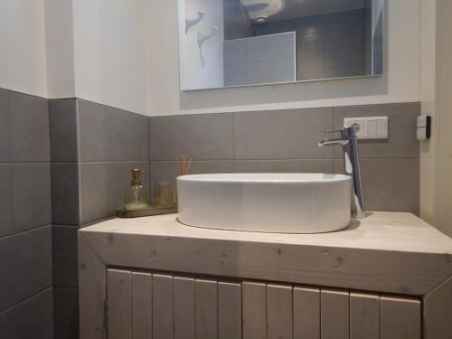 een badkamer met een witte wastafel en een spiegel bij monumentaal huisje Bed & Meer in Veere