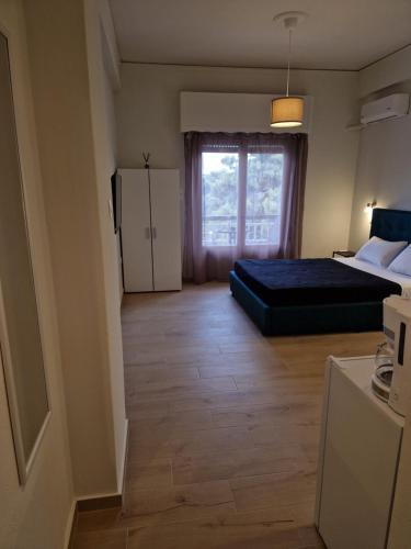 a small bedroom with a bed and a window at Above Apartments near the Airport in Artemida