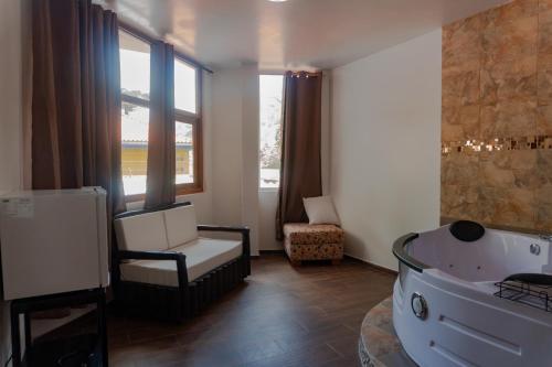 a bathroom with a tub and a chair and window at Hotel De Mi Pueblo in Baños