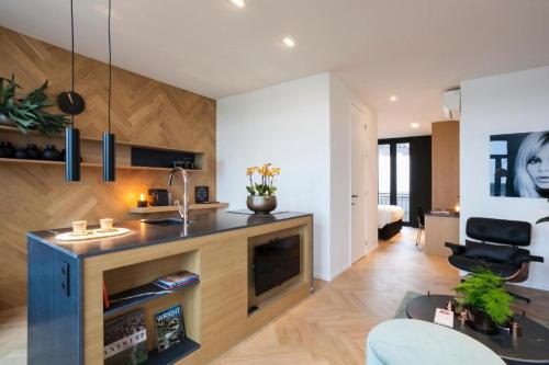uma sala de estar com uma cozinha com um balcão e uma televisão em Kaai11, Boutique Hotel Riverview em Antuérpia