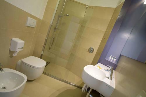 a bathroom with a shower and a toilet and a sink at Hotel Emilia in Ancona