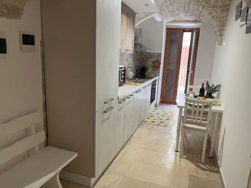 a kitchen with white cabinets and a table at ACANTHUS in Terlizzi