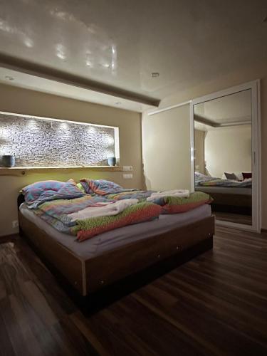 1 dormitorio con 1 cama con espejo grande en Допълнителна къща за гости Ози 2, en Ovchartsi