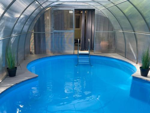 een binnenzwembad in een koepelhuis met blauw water bij Harzhotel Warnstedter Krug in Thale