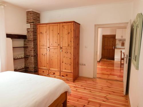 a bedroom with a bed and a wooden cabinet at Heltau Apartments in Cisnădie