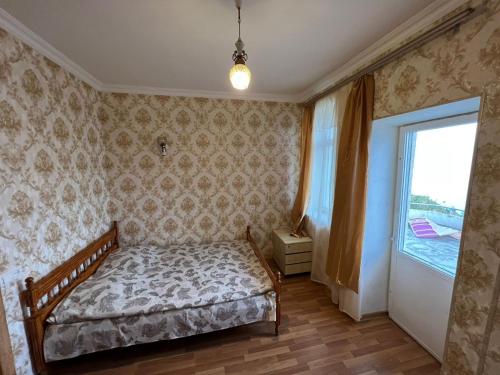 a bedroom with a bed and a large window at Sevan Writers House in Sevan