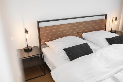 two white beds in a room with a headboard at Koje Drei I Zentrales Apartment mit Parkplatz in Bremerhaven