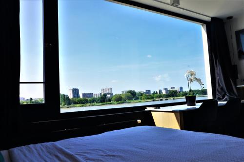 a bedroom with a large window with a view of the city at Kaai11 - Riverview Lofts & Suites in Antwerp