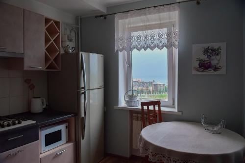 チョロノモスクにあるApartment on Parkova 36のキッチン(冷蔵庫、テーブル付)、窓が備わります。