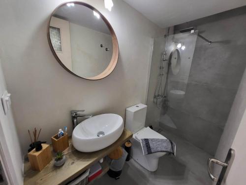 a bathroom with a sink and a mirror and a toilet at Stavros Residence in Mármara