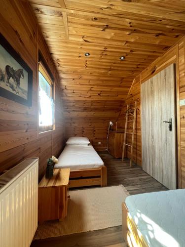 a room with two beds in a wooden cabin at Domki Teo Piętrowe I Parterowe in Rewal
