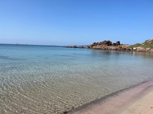 a large body of water with rocks in the distance at Appartamento vicino spiaggia in Portoscuso