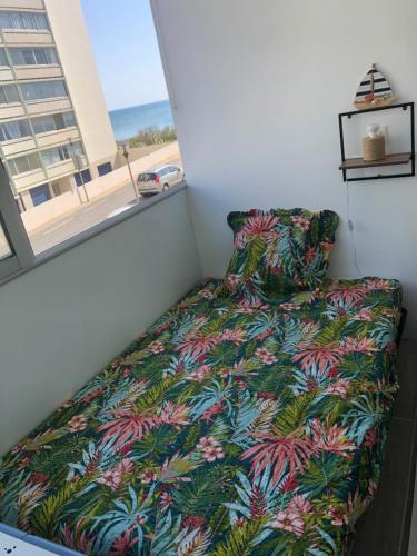 un lit dans une petite pièce avec une fenêtre dans l'établissement Studio vue mer, à Saint-Hilaire-de-Riez