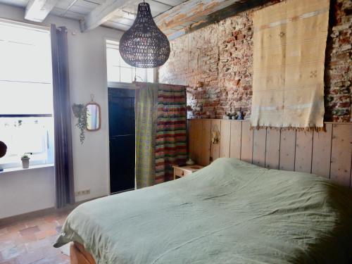 een slaapkamer met een bed en een bakstenen muur bij monumentaal huisje Bed & Meer in Veere