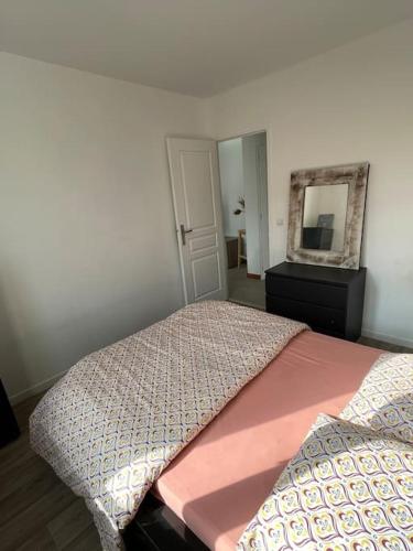 a bedroom with a bed and a dresser and a mirror at Home DisneyLand Paris avec Parking wifi in Lagny