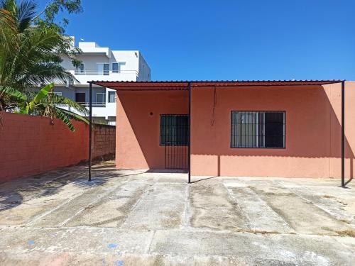 a orange building with a fence in front of it at Casita Mahahual 2, Grand Costa Maya in Mahahual