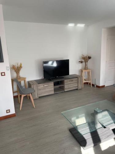 a living room with a tv and a glass table at Home DisneyLand Paris avec Parking wifi in Lagny