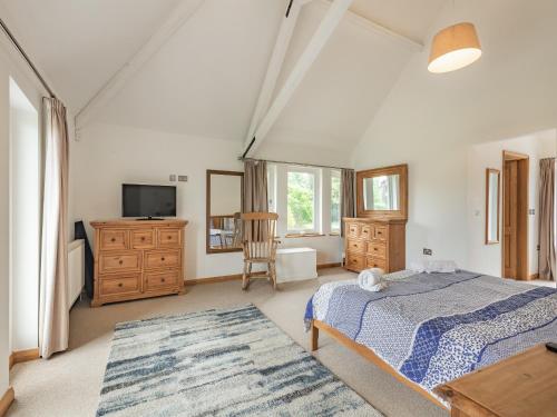 a bedroom with a bed and a dresser and a tv at Broad View in South Walsham