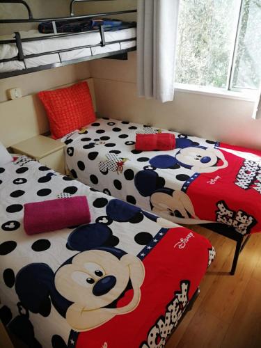 a bedroom with two beds with a mickey mouse blanket at The Farm Tiny House - Tiny Casa in Chiclana de la Frontera