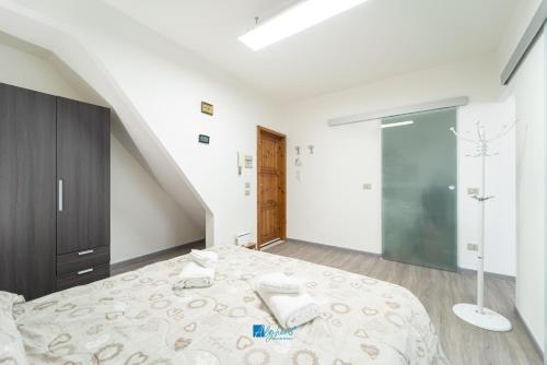 Un dormitorio blanco con una cama y una escalera. en City Center white, en Alghero