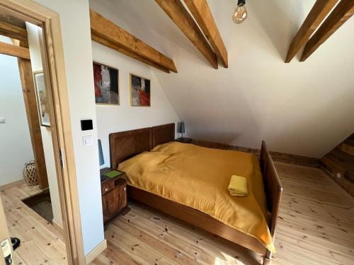 een slaapkamer met een bed in een kamer met houten vloeren bij 120 letnia Chata w Górach z jacuzzi i sauną 
