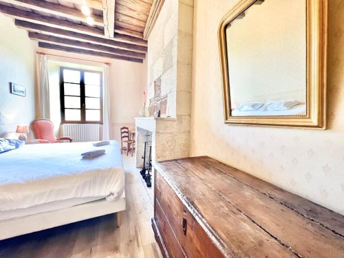 a bedroom with a bed and a mirror on the wall at Au Domaine Valigny, piscine chauffée + WIFI Fibre in Saint-Benoît