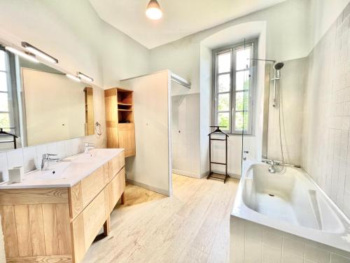 a bathroom with two sinks and a tub and a shower at Au Domaine Valigny, piscine chauffée + WIFI Fibre in Saint-Benoît