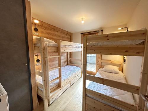 quelques lits superposés dans une chambre dans l'établissement Bel appartement neuf aux Gets, proche des pistes, avec terrasse et parking sécurisé - FR-1-623-335, aux Gets