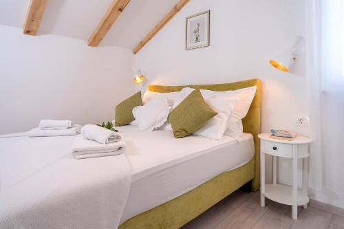 1 dormitorio con 1 cama con sábanas y almohadas blancas en Hvar town - Elegance & Brand New en Hvar