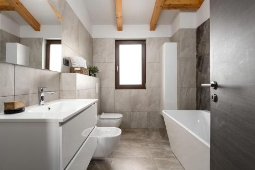 ein Badezimmer mit einem Waschbecken, einer Badewanne und einem WC in der Unterkunft Casa Pinia with outdoor jacuzzi in Poreč