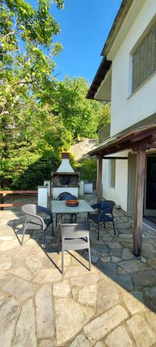 a patio with a table and chairs next to a building at Deluxe house in Tsangarada in Tsagarada