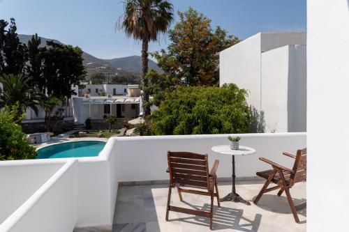 a balcony with a table and chairs and a pool at Galinos Hotel for adults only in Parikia