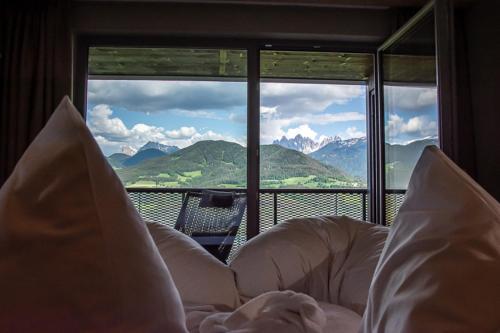 a bed in a room with a view of a mountain at feldthurnerhof vinum-natur-relax in Feldthurns