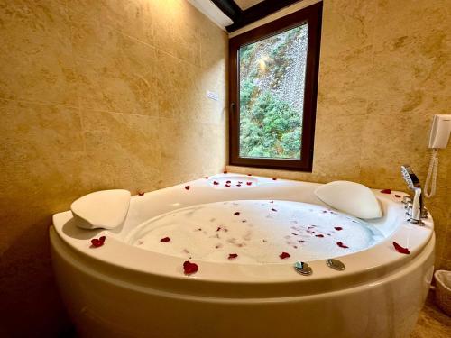 a bathroom with a bath tub with a window at Hatun Inti Boutique in Machu Picchu