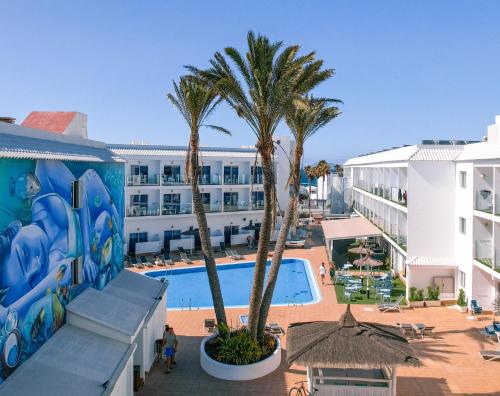 an aerial view of the resort with palm trees and a swimming pool at Corralejo Surfing Colors Hotel&Apartments in Corralejo